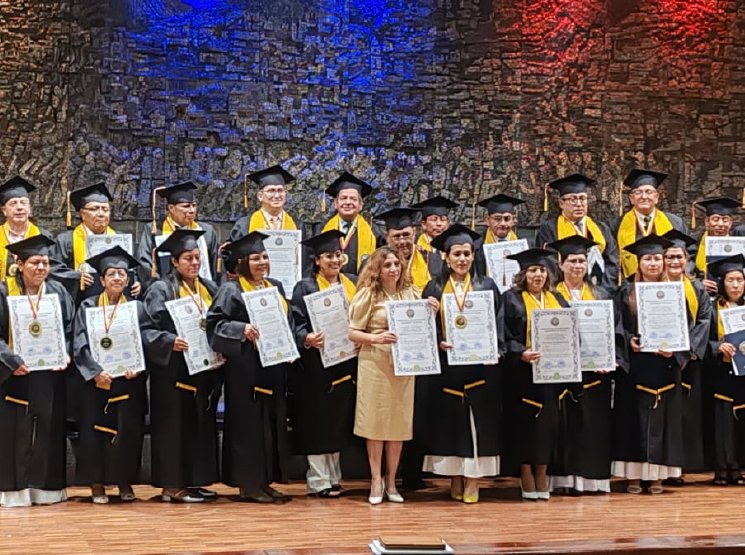 Graduados con toga y banda dorada mostrando sus diplomas en el escenario