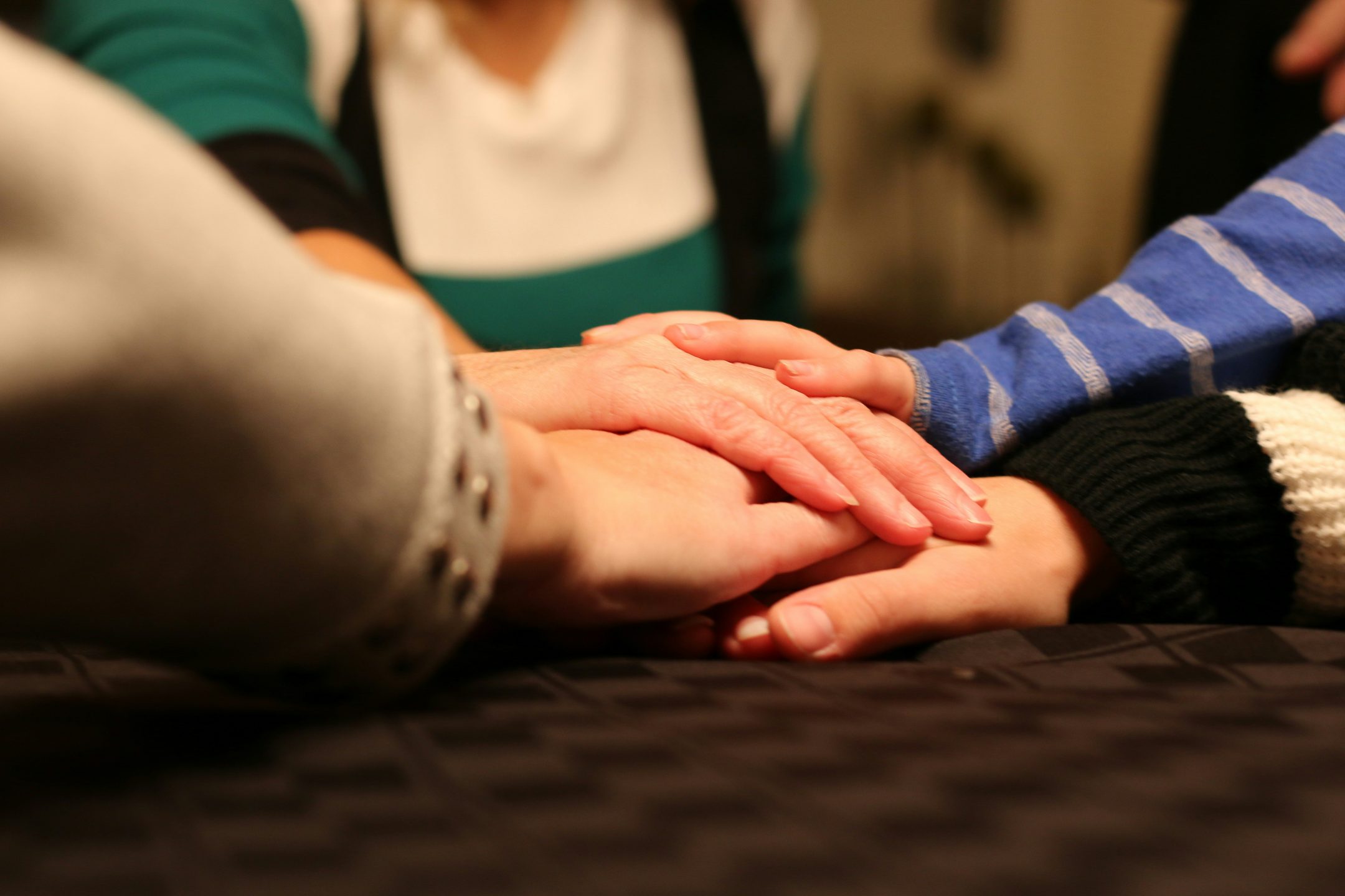 Manos de varias personas unidas sobre una mesa