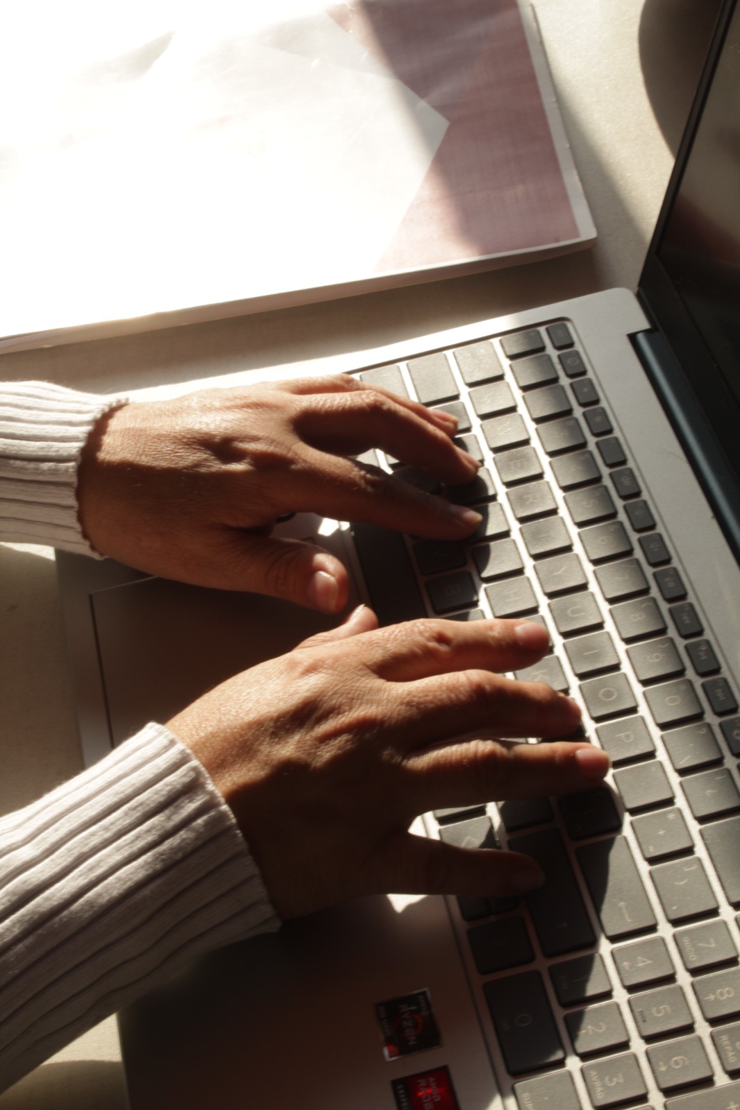 Manos escribiendo en el teclado de una laptop